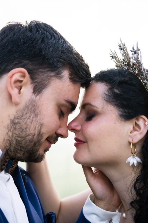 couple de mariés front contre front souriant en ayant les yeux fermés