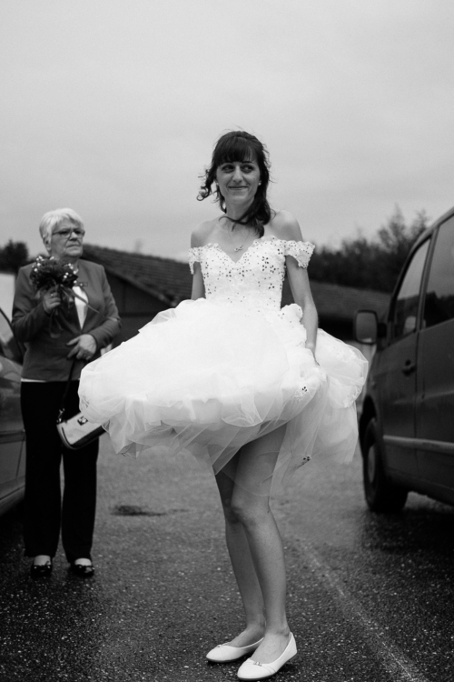 Mariée soulevant sa robe pour ne pas l'abimer avec la boue